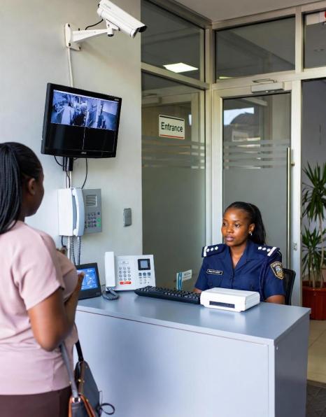 Executive security receptionist assisting visitors in a corporate lobby
